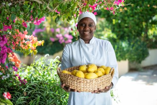 a woman is holding a basket of lemons at Last Word Constantia in Cape Town