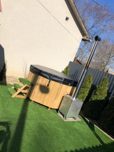 a wooden structure on the grass in a yard at Sirály Apartman in Hajdúnánás