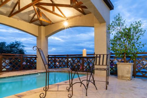 a patio with a swimming pool and a table and chairs at Haus Schwerinsburg Guest House in Windhoek