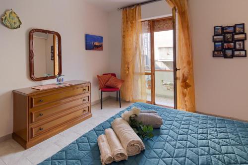 een slaapkamer met een blauw bed, een dressoir en een spiegel bij Casa vacanze santantioco in SantʼAntìoco