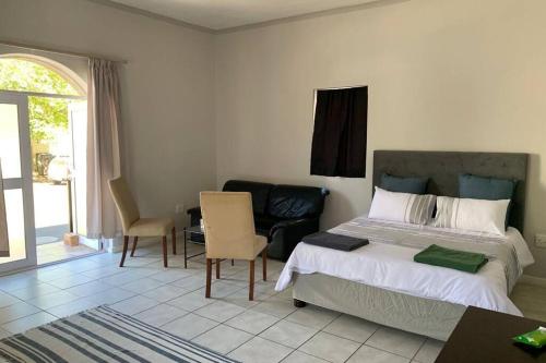 a bedroom with a bed and a table and chairs at Bright open-plan apartment close to wine tram in Franschhoek