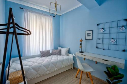 a bedroom with blue walls and a bed and a chair at Marilù- The downtown suite in Corfu Town
