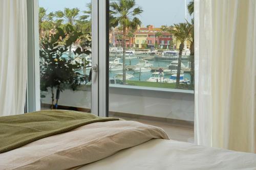 a bedroom with a window with a view of a marina at NEW & Modern Apartment - Marina, Sotogrande in Sotogrande