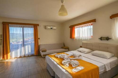 1 dormitorio con 1 cama grande y toallas. en Ankakyaka Apart Hotel, en Muğla