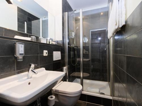 a bathroom with a sink and a toilet and a shower at Romantik Jugendstilhotel Bellevue in Traben-Trarbach