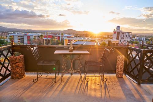 a balcony with a table and chairs on top of a city at Haus Schwerinsburg Guest House in Windhoek