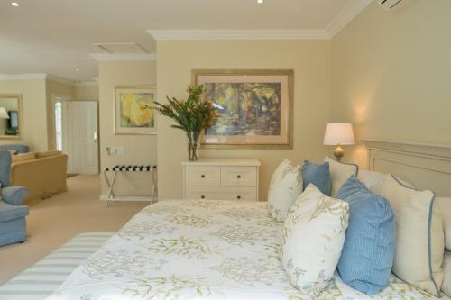 a bedroom with a bed with blue and white pillows at Last Word Constantia in Cape Town
