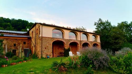 an old brick building with large windows on a yard at Antico Convento in Garessio