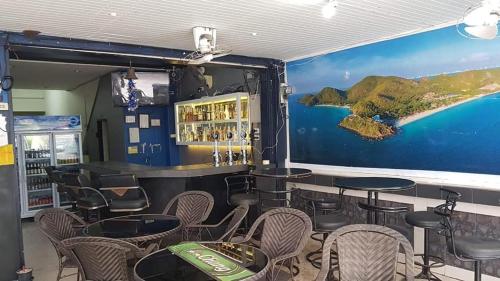 a restaurant with tables and chairs and a mural at Welcome Lounge in Jomtien Beach