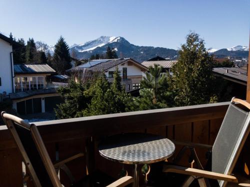 una mesa y sillas en un balcón con montañas en BERGFEX Gaisalphorn mit Sommer-Bergbahnticket, en Oberstdorf