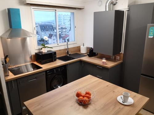 Appartement tout confort 2 chbres - 72m2 - avec terrasse et vue Pyrénées في بو: مطبخ مع صحن من الفواكه على طاولة