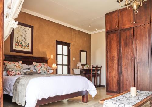 a bedroom with a large bed and a desk at Haus Schwerinsburg Guest House in Windhoek