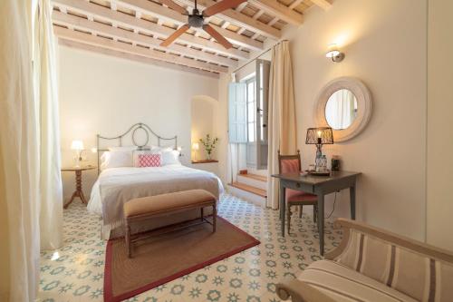 a bedroom with a bed and a table and a mirror at Casa Shelly Hospedería in Vejer de la Frontera