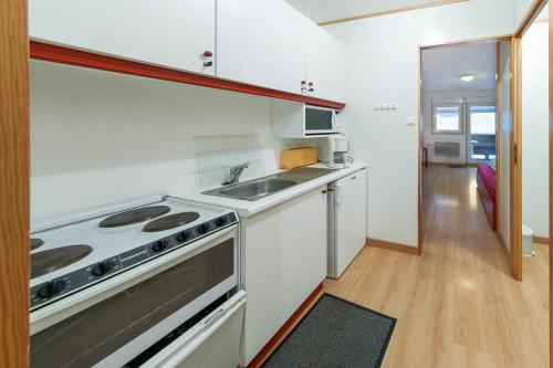 une cuisine avec une cuisinière et un évier dans l'établissement Studio accueillant à Gérardmer 31 m² avec vue montagne, à Gérardmer