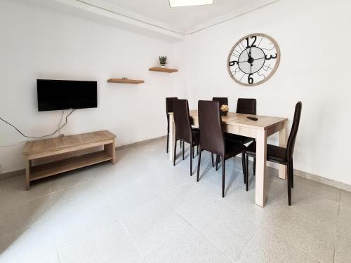 comedor con mesa y reloj en la pared en Apartamento completo Plaza España II, en Benidorm