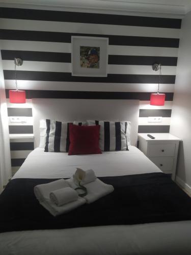Schlafzimmer mit einem Bett mit schwarzen und weißen Streifen in der Unterkunft FerhouseDreams-Praia in Nazaré