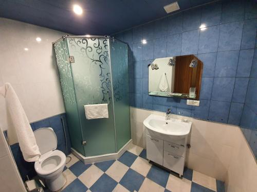 y baño con ducha, aseo y lavamanos. en Tatev Apartments, en Ereván