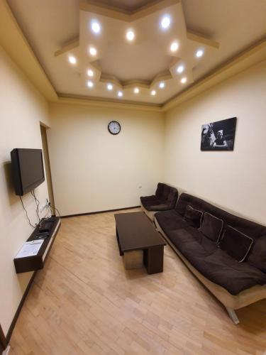 a living room with a couch and a tv at Tatev Apartments in Yerevan