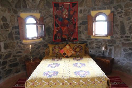 Complexe touristique FORT BOU-JERIF في كلميم: غرفة نوم بسرير مع نافذتين