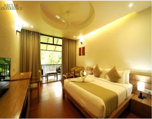 a bedroom with a bed and a desk and a window at Whispering Waters in Malayāttūr
