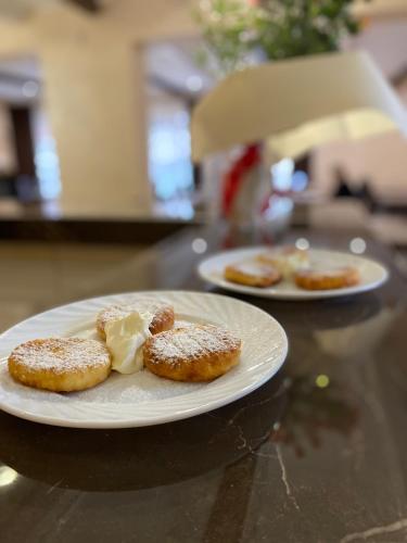 two plates of donuts with butter on a table at Солодкий Гранат in Slavske