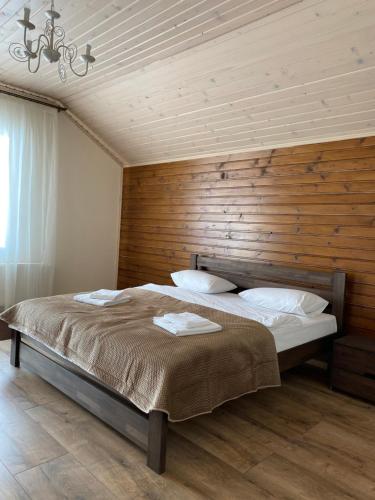 a bedroom with a bed with a wooden wall at Солодкий Гранат in Slavske