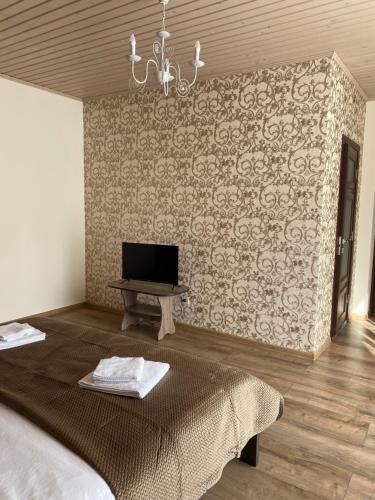 a bedroom with a bed and a tv on a wall at Солодкий Гранат in Slavske