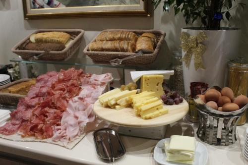een tafel met kaas, vlees en eieren bij Hotel Aurora Mare in Rimini