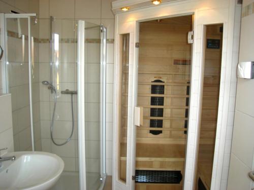 ein Bad mit einer Dusche und einem Waschbecken in der Unterkunft Strandläufer Zempin in Zempin