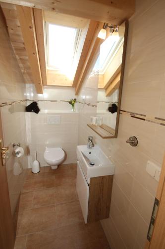 a bathroom with a sink and a toilet and a window at Ferienwohnung Fagerer in Piding
