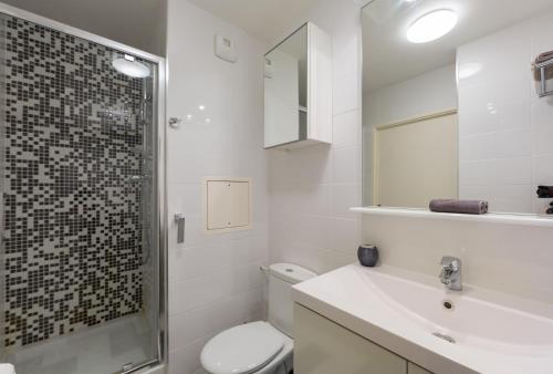 a bathroom with a toilet and a sink and a shower at studio tout confort près de Disney in Serris