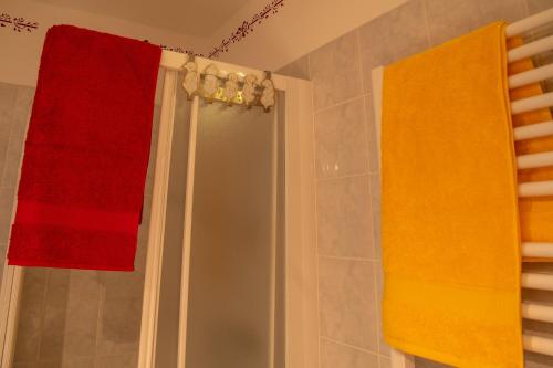 two colorful towels are hanging in a bathroom at Haus am Römerbad in Bad Kleinkirchheim