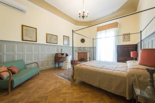 ein Schlafzimmer mit einem Bett und einem Sofa in der Unterkunft VIlla Merlo Ner0 in Florenz