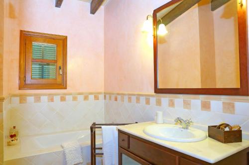 a bathroom with a sink and a tub and a mirror at Finca Son Rossinyol 128 by Mallorca Charme in Sineu