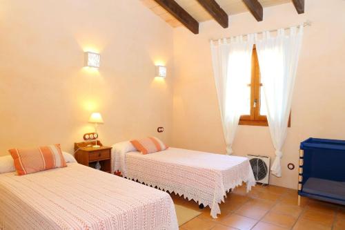 Un dormitorio con 2 camas y una ventana con una cruz en Finca Son Rossinyol 128 by Mallorca Charme, en Sineu