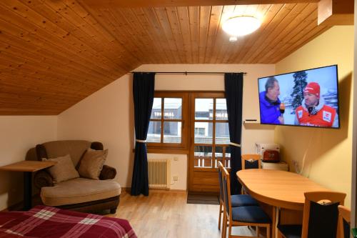 a living room with a tv on the wall at Haus am Römerbad in Bad Kleinkirchheim