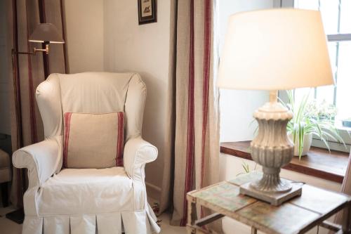 a living room with a chair and a lamp on a table at Casa Shelly Hospedería in Vejer de la Frontera