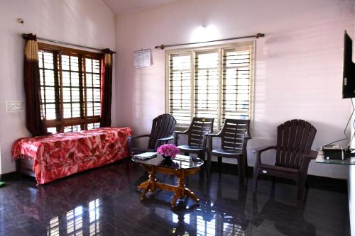 - un salon avec des chaises, un canapé et une table dans l'établissement Naturesky Homestay - Full Villa, Home Food & Coffee Estate, à Chikmagalur