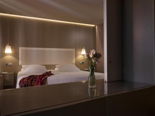 a hotel room with a bed and a vase of flowers at SAZ City Life Boutique Hotel in Ioannina