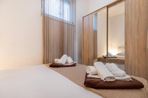 a bedroom with a bed with towels and a mirror at Apartments Grof in Selce