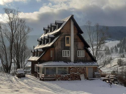 Cabana de pe stanca - hotel في Cîrlibaba Nouă: منزل فيه ثلج على السطح في الثلج