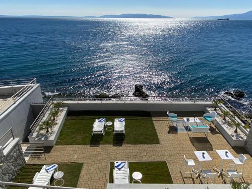 an outdoor patio with chairs and tables and the ocean at RIA Lungomare in Rijeka