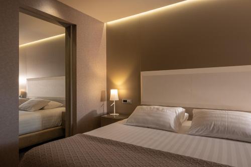 a hotel room with two beds and a mirror at SAZ City Life Boutique Hotel in Ioannina