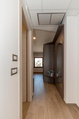 a hallway with wooden floors and a door with a window at Hotel Da Si-Si in Gemona del Friuli