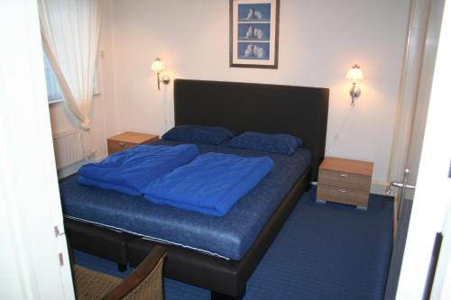 Un dormitorio con una cama con sábanas azules. en Schorrebloem 1, en Nieuwvliet