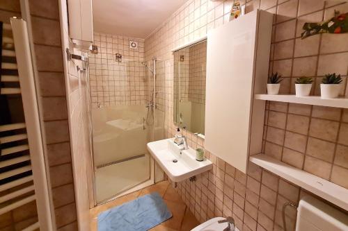 a small bathroom with a sink and a shower at Three Mermaids House in Piran