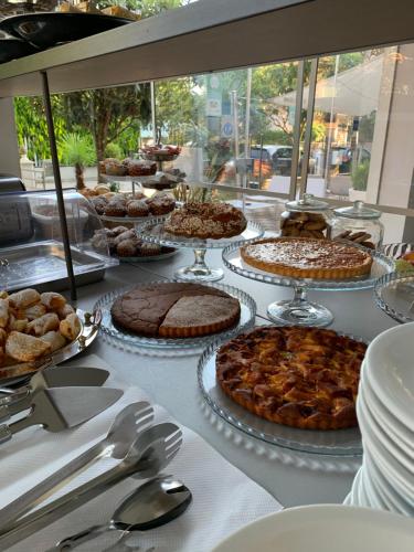 a table with many cakes and pies on it at Villa Liliana in Cervia