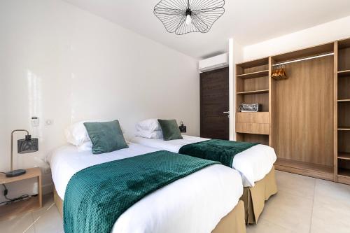 a bedroom with two beds and a closet at Résidence U Manellu in Santa-Reparata-di-Balagna