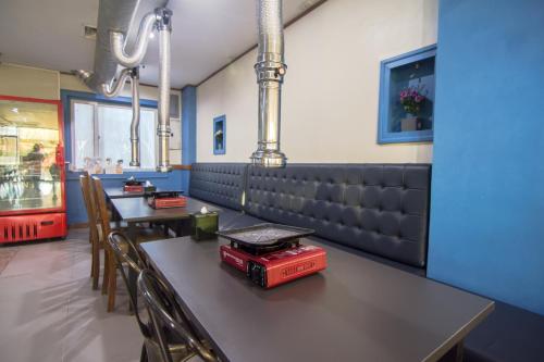 a restaurant with a table and chairs and a bench at DG Grami Hotel in Manila