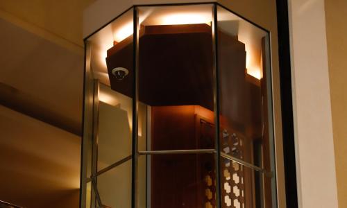 a glass shower door with a light on the wall at Crowne Plaza Sohar by IHG in Sohar